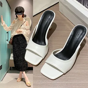Close-up of white square toe stiletto mules with comfortable black footbed padding