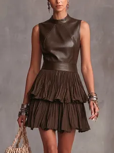 Gros plan détaillé montrant le cuir PU texturé et l'ourlet plissé étagé sur cette robe marron