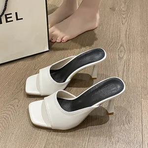 High-angle detailed view of elegant white square-toe stiletto heel mule sandals.