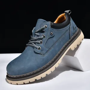 Close-up of blue suede mid-top work boots with chunky beige lug sole and laces