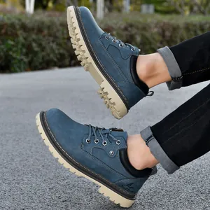 Detail shot of blue mid-top work boots with rugged lug soles shown on a male model