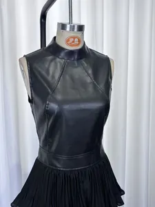 Détail rapproché d'une robe noire sans manches en similicuir avec jupe plissée