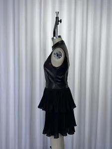 Détail de profil d'une robe noire sans manches en similicuir PU avec ourlet plissé à volant