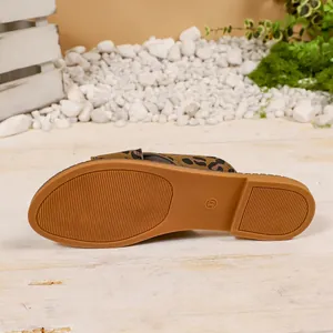 Detail view of the durable rubber sole and leopard print strap of women's flat sandals