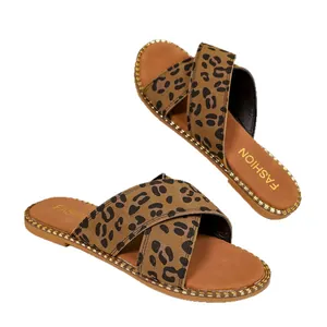 Elegant leopard print flat sandals for women featuring stylish cross-strap and gold trim