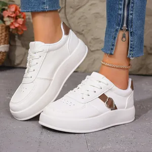 Detalle de zapatillas blancas de plataforma con un diseño de corazón en el lateral.