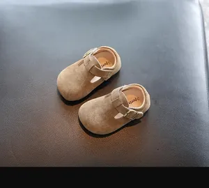 Détail de chaussures à boucle en T en daim marron pour tout-petits à semelles souples
