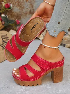 Detail von roten PU-Plateau-Sandalen mit hohem Blockabsatz und Klettverschluss.