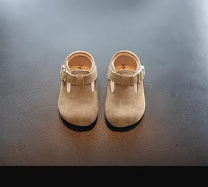 Vue détaillée de dessus de chaussures en daim marron pour bambins avec bride en T et boucle.