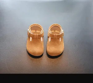 Détail de chaussures de marche pour tout-petits en daim marron avec boucle