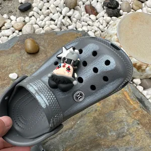 Detailweergave van grijze waterdichte kinderklomp met decoratieve cartoon personage bedel