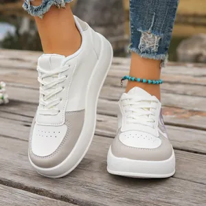 Vista frontal de zapatillas blancas con plataforma en un modelo en exteriores