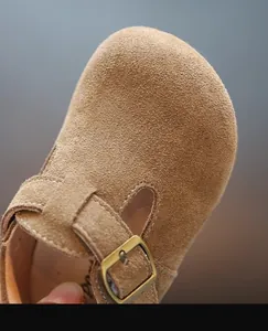 Gros plan d'une chaussure pour tout-petit en daim marron avec boucle et semelle souple