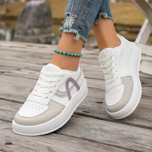 Primer plano de zapatillas blancas de mujer con suela gruesa y detalles lavanda modernos