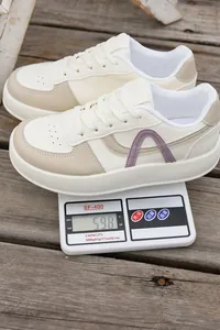Primer plano que muestra el peso de las zapatillas de plataforma crema en una báscula