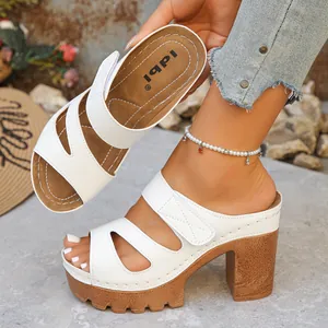 Nahaufnahme weißer Plateau-Sandalen mit Klettverschluss und Cut-out-Design für Damen.
