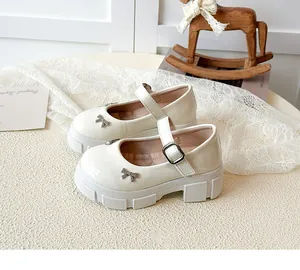 Elegant white patent leather Mary Jane shoes with thick platform sole and rhinestone bow detail