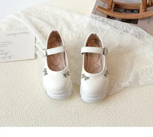 High-angle detailed shot of white retro thick-sole Mary Jane shoes with crystal bow