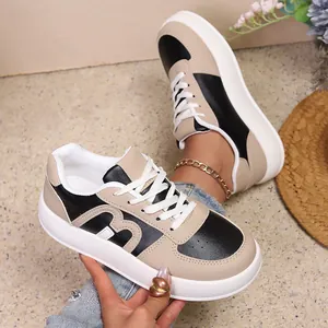 Vista detallada de las zapatillas de plataforma para mujer en beige y negro con cordones.