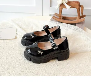 Close-up of black patent leather Mary Jane shoes with thick soles and bow details