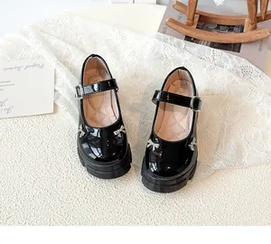 Detailed view of black patent leather Mary Jane shoes with thick soles and bow accents.