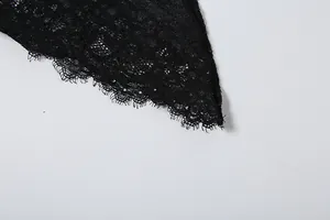 Nahaufnahme der feinen schwarzen Wimpernspitze an einem eleganten Kleiderdetail