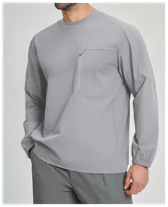 Dettaglio maglia outdoor grigia a maniche lunghe con tasca sul petto con zip.