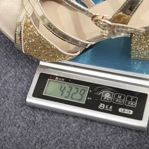 Vista detallada que muestra el peso de 432,9g de la sandalia dorada con pedrería y tacón ancho