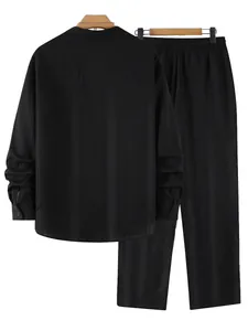 Back view of black long-sleeved shirt and trousers set with subtle vertical stripes