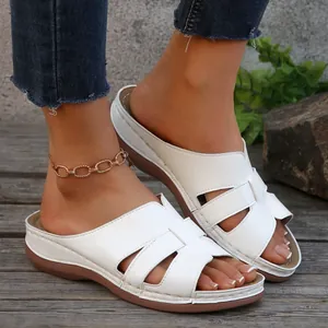 Vista macro detallata de cómodas sandalias de cuña blancas sobre una superficie de madera