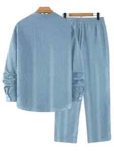 Back view of light blue striped men's shirt and trousers set displayed on wooden hangers