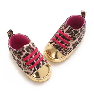 Close-up of leopard print baby walking shoes with gold toe caps and pink laces