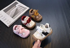 Vista dettagliata di varie scarpe da primi passi per neonati con suola morbida colorate.