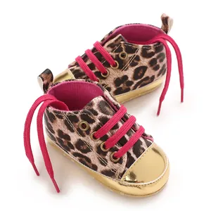 Macro view of leopard print baby walking shoes with pink laces and gold toe caps.