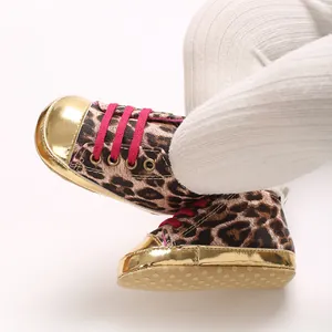 Close-up of leopard print baby walking shoes with gold metallic toe caps and pink laces