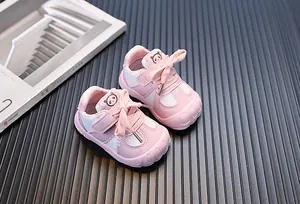 Dettaglio scarpe primi passi rosa per neonati con suola morbida e logo panda carino.