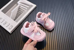 Dettaglio di scarpine primi passi rosa per neonati con suola morbida e logo panda carino.
