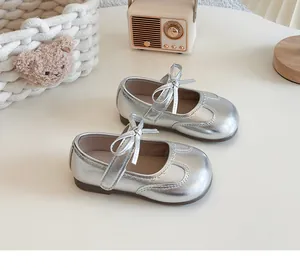 Detailed top view of silver girls' Mary Jane shoes with bow and scalloped trim detail