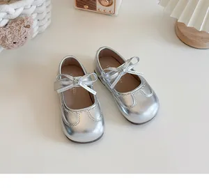 Close-up of silver girls' Mary Jane shoes featuring a cute bow detail and metallic finish