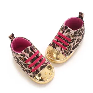 Detailed view of leopard print baby shoes with pink laces and gold studded metallic toes