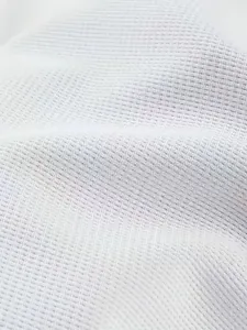 Nahaufnahme der hochwertigen weißen Waffelstrick-Struktur für ein Herren-Kapuzenshirt
