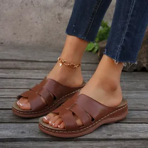 Vista detallada de cómodas sandalias de cuña marrones para mujer en una terraza de madera
