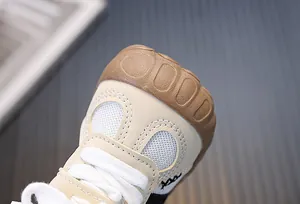 Dettaglio della punta di una scarpa per bambini in mesh beige con suola in gomma