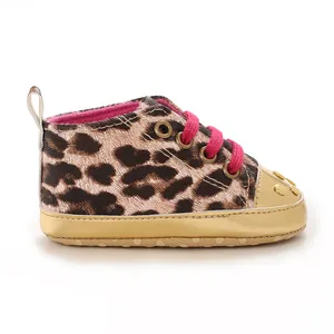 Close-up of stylish leopard print baby walking shoe with vibrant pink laces and gold accents