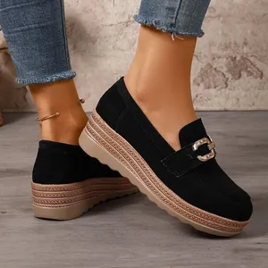 Detailaufnahme von schwarzen Wildleder-Plateau-Loafers mit goldener Kettenschnalle