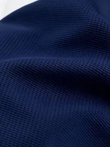 Nahaufnahme des dunkelblauen Waffelstrickstoffs für ein amerikanisches Herren-Hoodie.