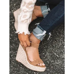 Detailed view of women's camel suede wedge sandals featuring an espadrille platform.