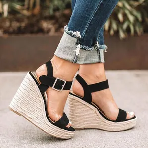 Detailed view of women's black ankle strap wedge sandals with braided jute platform