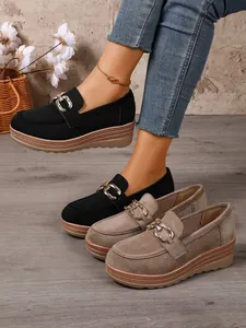 Detailansicht der Wildlederstruktur und der Metallkettenschnalle von Damen-Loafers