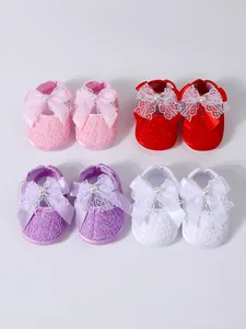 Detailed view of infant soft-soled lace shoes in four colors with decorative bows and pearls